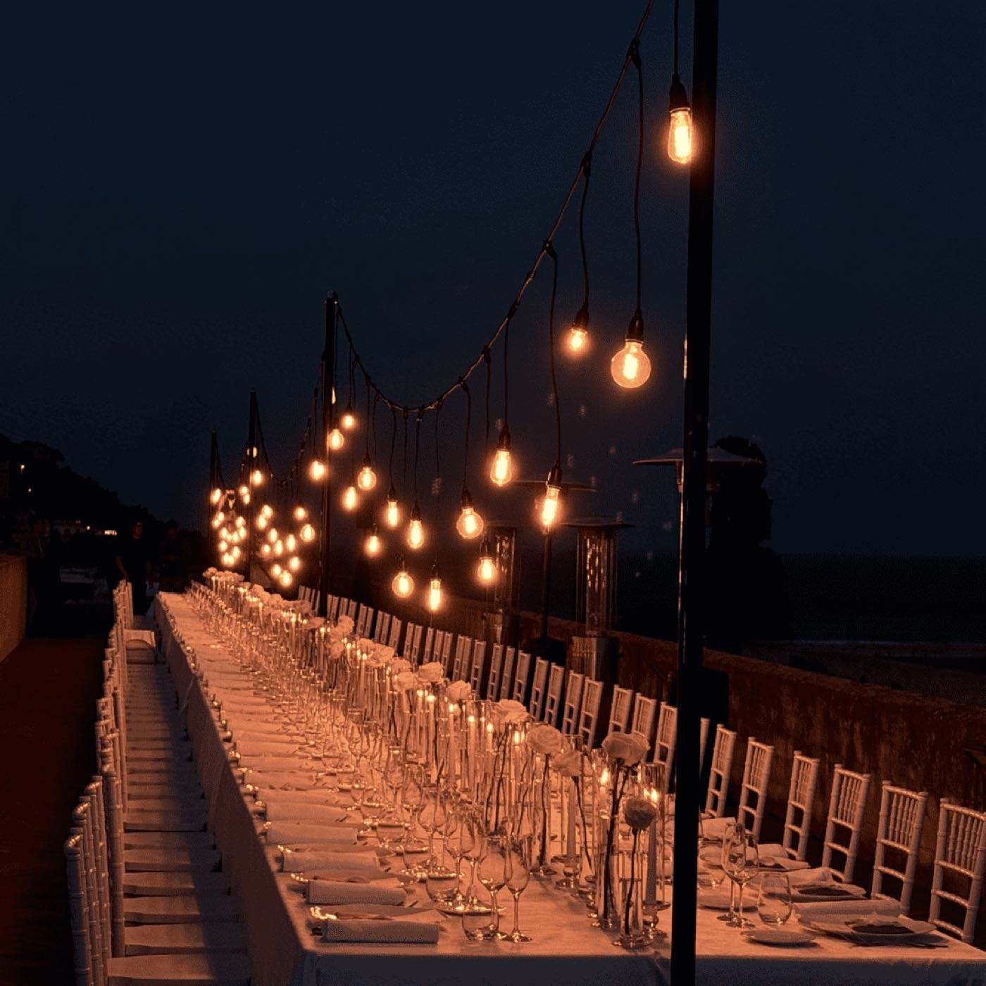 Catenarie di lampadine che illuminano il percorso di un evento