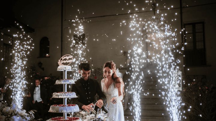 Taglio della torta con fontane fredde durante un matrimonio